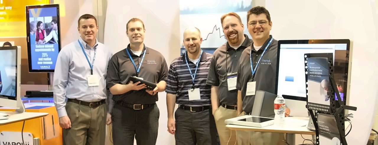 The first Graphium Health team, five people standing in a trade-show booth